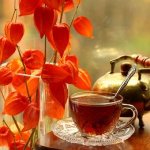 Чашка ароматного чая, рядом цветы смайлик гиф анимация картинки
